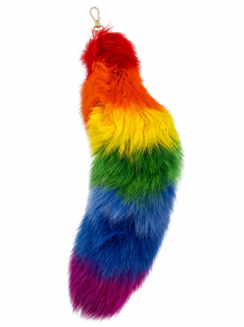 A fluffy fox fur rainbow tail, featuring red, orange, yellow, green, blue, and purple stripes with a small gold metal ring at the top, shown on a plain white background.