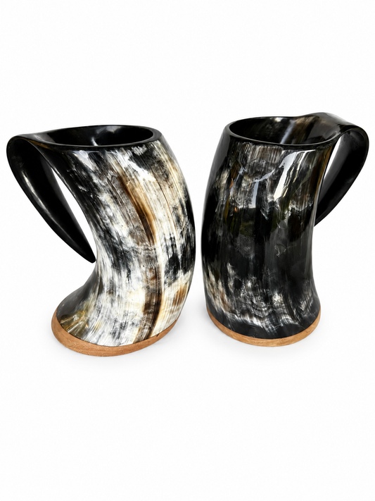 Two curved horn-shaped cups with glossy black, white, and tan marbled patterns, shown on a plain white background.
