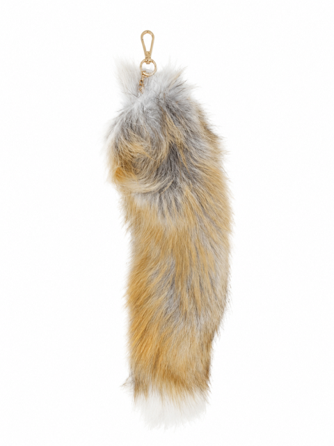 A long, fluffy fox-fur tail accessory in natural fox tones of tan, brown, and gray, with a small gold-tone metal clasp at the end, shown on a plain white background.