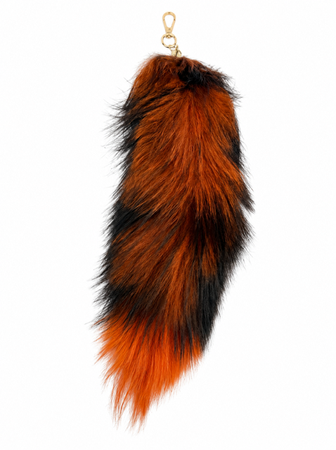 A fox fur keychain or bag charm shaped like a fox tail, featuring a vibrant orange and black mottled pattern with a small gold metal clasp at the top, shown against a plain white background.